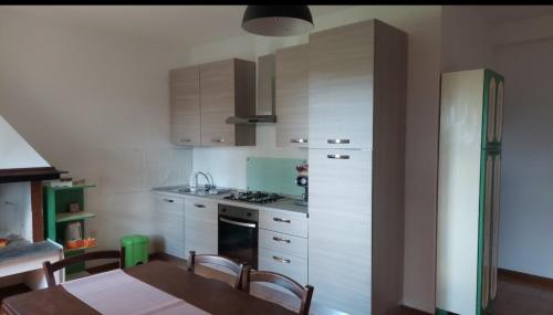 a kitchen with a table and a stove and cabinets at Agriturismo Podernuovo in Acquapendente