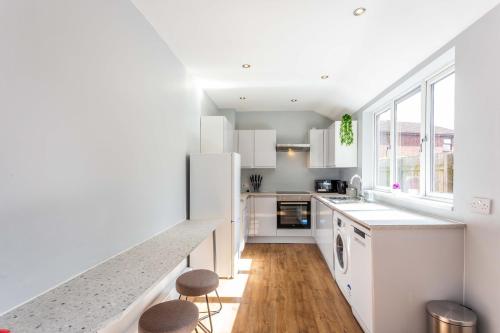 cocina con electrodomésticos blancos y suelo de madera en Spectacular House with Patio in Carlisle, en Carlisle