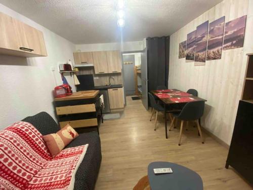 un salon avec un canapé et une table et une cuisine dans l'établissement Appartement dans chalet Les Deux Alpes, à Les Deux Alpes