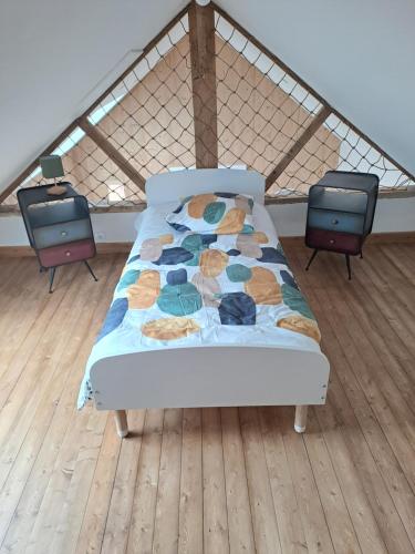 - un lit dans une chambre avec 2 chaises dans l'établissement Les Goelettes à 250 m de la plage, à Barneville-Carteret