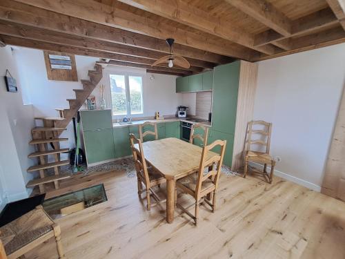 une cuisine avec une table et des chaises dans une pièce dans l'établissement Les Goelettes à 250 m de la plage, à Barneville-Carteret