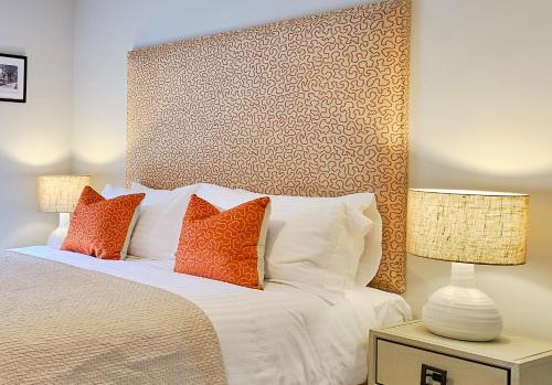 a bedroom with a bed with two pillows and two lamps at Lambert House in Harrogate