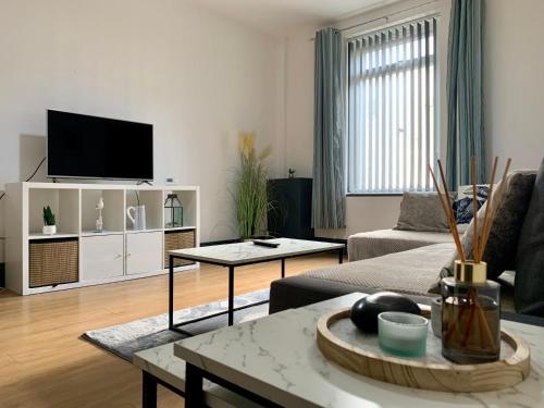 a living room with a couch and a tv at Cheerful - 3 Bed - Serviced Accommodation - In Heart of Northumberland - Sleeps 6 in Bebside