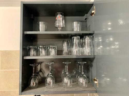 a bunch of glass bottles and glasses on shelves at Cheerful - 3 Bed - Serviced Accommodation - In Heart of Northumberland - Sleeps 6 in Bebside