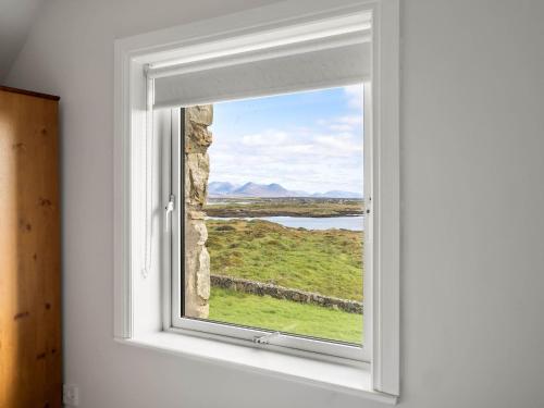 a window with a view of a green field at Lake House Mannin, Ballyconneely in Ballyconneely