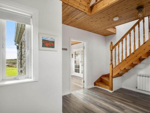 a staircase in a home with a wooden ceiling at Lake House Mannin, Ballyconneely in Ballyconneely