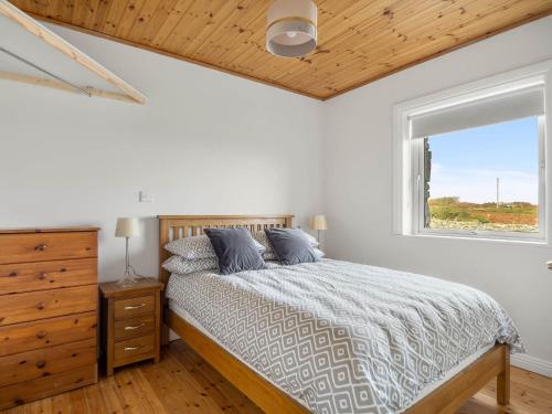 1 dormitorio con cama y ventana en Lake House Mannin, Ballyconneely, en Ballyconneely