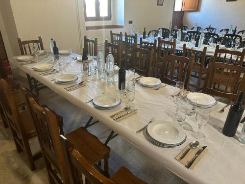 une longue table avec des assiettes et des verres dans l'établissement HOTEL RURAL LOS FAROLES, à Huérmeces