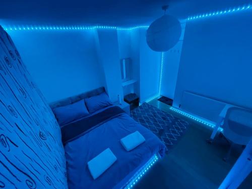 een blauwe slaapkamer met een bed en een bureau bij Flat A in Londen