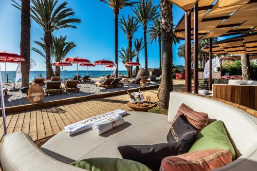 un resort con palme e sedie sulla spiaggia di Hotel Vibra Algarb a Playa d'en Bossa