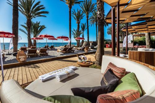 un complejo con palmeras y sillas en la playa en Hotel Vibra Algarb, en Playa d'en Bossa