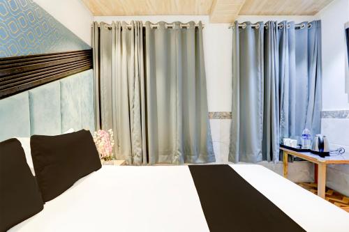 um quarto com uma cama grande e cortinas azuis em OYO Hotel Diamond Residency em Mumbai