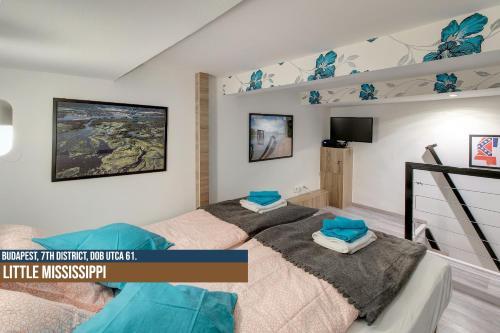 um quarto com uma cama grande e almofadas azuis em Little Americas Ring Apartments em Budapeste