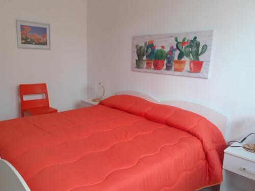 a bed with a red comforter in a bedroom at B&B Villa Rosina in Satriano di Lucania