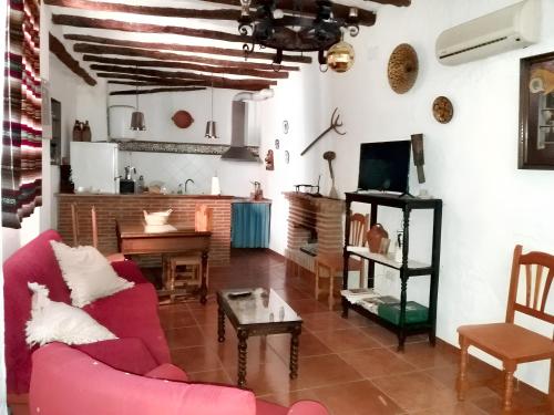 sala de estar con sofá rojo y mesa en 6 bedrooms house with balcony at Quesada, en Quesada