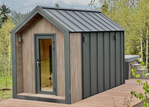 a wooden shed with a metal roof and a door at Domki Piwniczna in Piwniczna
