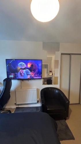 a living room with a couch and a flat screen tv at Ensuite Double Bedroom in a 2 bed Spacious Apartment in Warrington