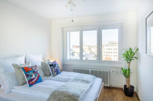 Sofá blanco en una habitación con ventana en Special PICCO PICASSO Apartment Basel, Bahnhof Grossbasel 10-STAR en Basilea