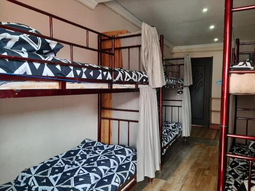 a room with three bunk beds in a house at Everyday Cat Hostel in Batumi