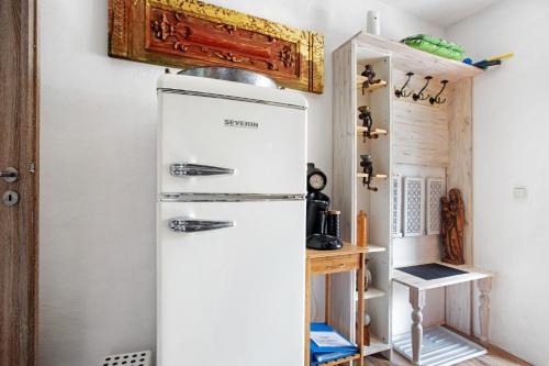 a white refrigerator in a kitchen with a shelf at Ferienwohnung beim Roana in Inzell