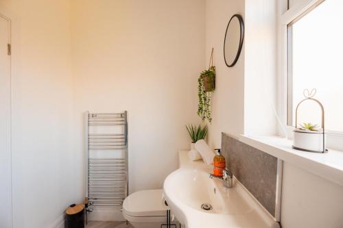 レッドカーにあるRedcar House By Horizon Staysの洗面台、トイレ、鏡のあるバスルーム