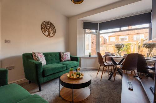a living room with a green couch and a table at Redcar House By Horizon Stays in Redcar