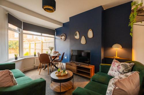 a living room with a green couch and a tv at Redcar House By Horizon Stays in Redcar