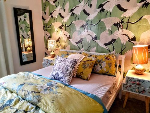 a bedroom with a bed with a floral wallpaper at 4 bedroom period Townhouse in the heart of Hebden in Hebden Bridge