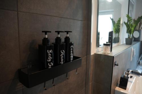 ein Regal in einem Badezimmer mit vier Flaschen darauf in der Unterkunft Fairmieten I Moderne Suite I Parkplatz in Bielefeld