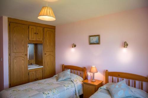 a bedroom with two beds and a lamp at Killary Vista in Renvyle