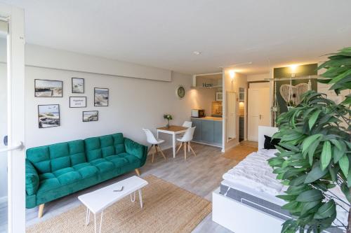 ein Wohnzimmer mit einem grünen Sofa und einem Tisch in der Unterkunft FeWo C 1-2 "Kleine Auszeit" in Sierksdorf