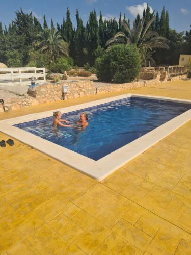 2 personas nadando en una piscina en Caravans spanien en La Marquesa