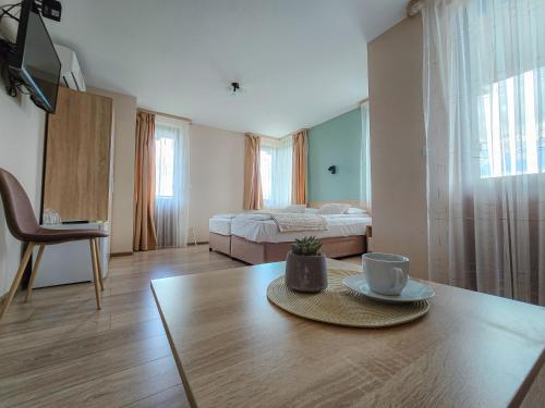 Cette chambre dispose d'une table avec une tasse de café. dans l'établissement Family Hotel "Slavianska dusha", à Veliko Tarnovo