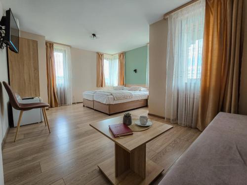 ein Schlafzimmer mit einem Bett und einem Tisch in einem Zimmer in der Unterkunft Family Hotel "Slavianska dusha" in Weliko Tarnowo