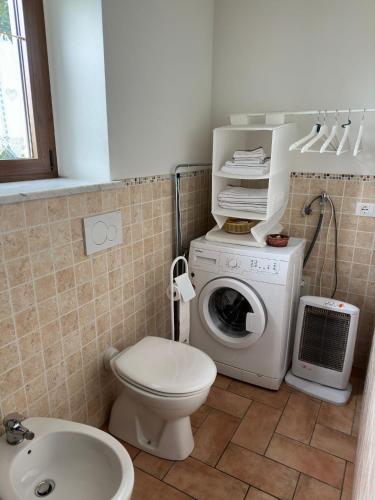 a bathroom with a toilet and a washing machine at La Casetta in San Giovanni delle Contee