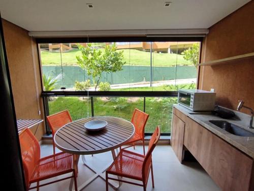 a kitchen with a table and chairs and a window at Beira-Mar EcoResort Carneiros perto da Igrejinha in Tamandaré