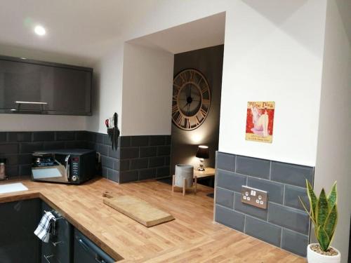 a kitchen with a counter and a clock on the wall at Walkers rest (Afan Valley) sleeps 5 in Cymmer