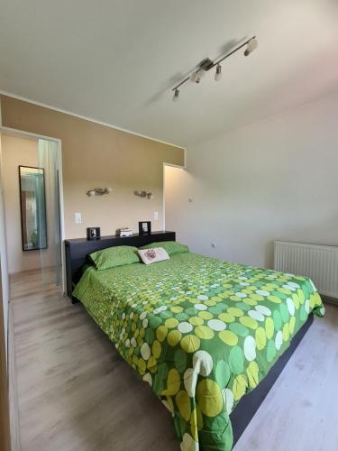 ein Schlafzimmer mit einem Bett mit einer grünen Bettdecke in der Unterkunft Hiška pod murvo - Kraški rob in Črni Kal