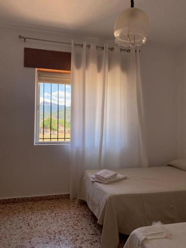 a white room with two beds and a window at Casa Rural Chache CASTO in Bienservida