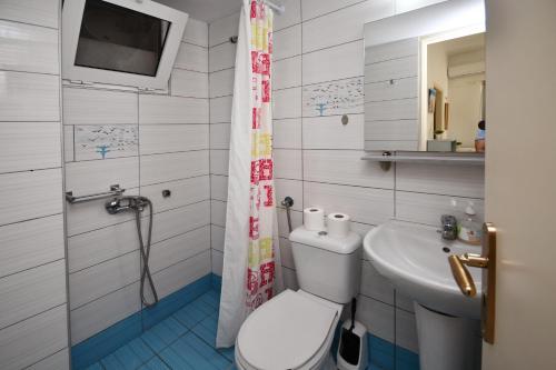 a bathroom with a toilet and a sink at Nikos House in Myrtos
