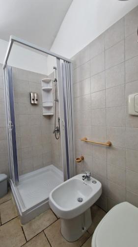 a bathroom with a shower and a toilet and a sink at Trullo Grande Noce in Ostuni