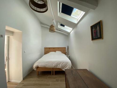 um quarto com uma cama e uma mesa de madeira em La Mauvernière, 2 gîtes indépendants, 1 grande piscine extérieure, jardin arboré em Descartes