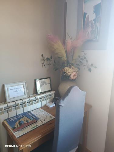 a desk with a vase of flowers and a vase at Apartamento Mirador del Pantano2 in Vinuesa