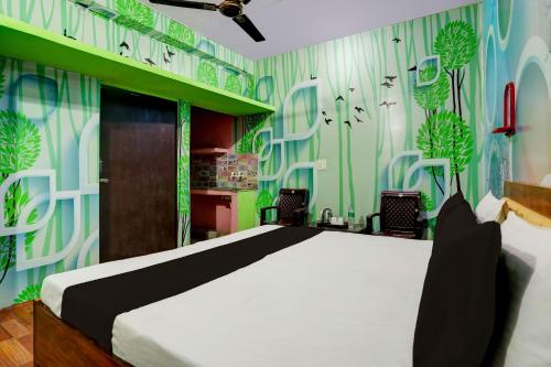 una camera da letto con un letto con carta da parati verde e bianca di OYO WELCOME GUEST HOUSE a Rudrapur