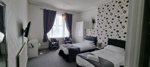 a hotel room with two beds and a window at Royal Pier in Sandown