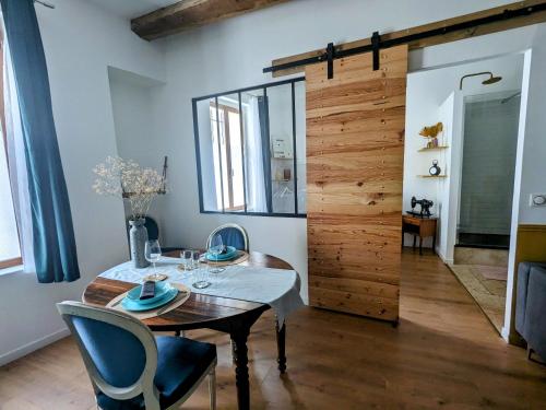 d'une salle à manger avec une table et une porte en bois. dans l'établissement Cocon chaleureux proche écusson, à Nîmes