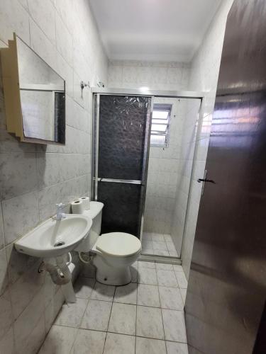 uma casa de banho com um WC, um chuveiro e um lavatório. em Cantinho do Mar Pousada em Bertioga