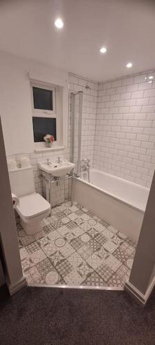 a bathroom with a toilet and a tub and a sink at 3 Bed Home sleeps 6 in Heart of Cardiff Free Parking in Cardiff
