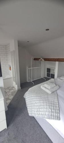 biała sypialnia z łóżkiem i schodami w obiekcie 3 Bed Home in Heart of Cardiff w Cardiff