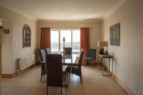 a dining room with a table and chairs and a window at Once Upon a Tide in Clifden